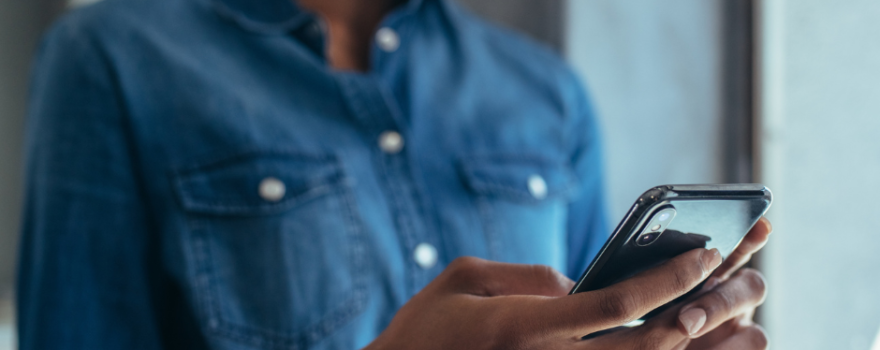 A woman in glasses is looking at her phone.